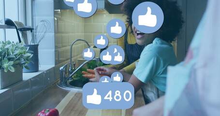 Two friends in aprons cleaning carrots under faucet at home kitchen sink, with floating 480 likes