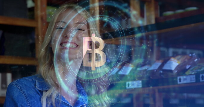 Smiling blonde woman standing in storeroom, with shelves, labeled boxes and crypto coin hologram - Powered by Adobe