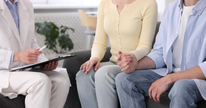 In vitro fertilization (IVF). Couple holding hands during appointment with doctor in reproductive clinic, closeup