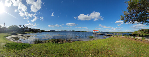 Lake Baldwin Park in Orlando, Winter Park, Florida, USA. Lake view landscape with red gazebo. Ecological Park for visitors on a travel vacation in Orlando, Florida, USA.