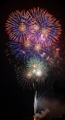 Brilliant burst of celebratory fireworks lighting up the night sky in vibrant colors