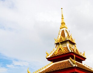 Fototapeta premium Golden roofed temple spire against cloudy sky
