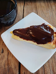 Pastel de Queso cubierto con chocolate y una taza de café, fotografía gastronómica con teléfono móvil. Toma Vertical.