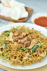 Indonesian style stir fry noodles with chicken, egg,  green mustard, and crackers.