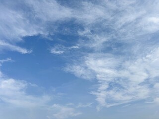 Blue sky with wispy cirrus clouds and a clear patch, perfect for a peaceful natural background