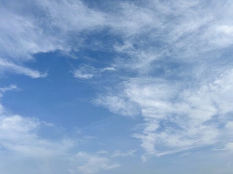 Blue sky with wispy cirrus clouds and a clear patch, perfect for a peaceful natural background