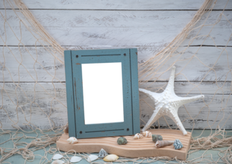 Coastal Beach Vibe closeup image with transparent picture photo frame, fishing net fishnet, shells, beach themed decorations on a weathered whitewashed wood backdrop and ocean blue green table counter