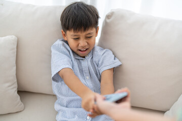 Child reaching for smartphone from parent, screen time control, tech addiction in kids, digital...