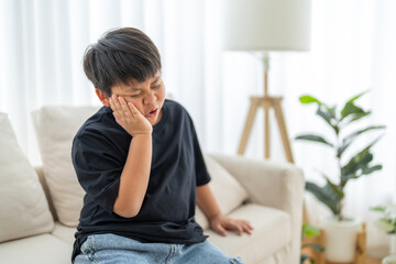 Young child experiencing toothache, tooth decay, childhood dental pain. The child facial...