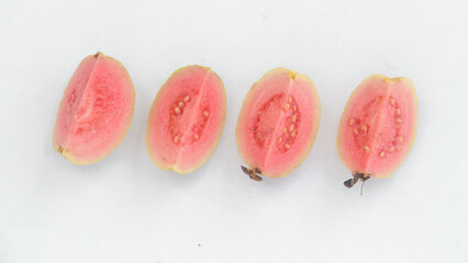 Fresh slices of guava fruit or Psidium Guajava arranged on a white background isolated
