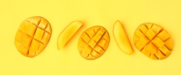 Fresh cut mangoes on yellow background