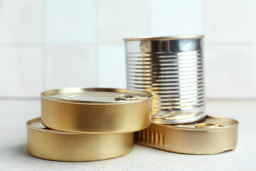 Tin cans with fish on white table
