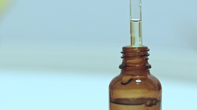 Selective focus to showcasing a glass bottle dropper containing organic serum, skincare and wellness product