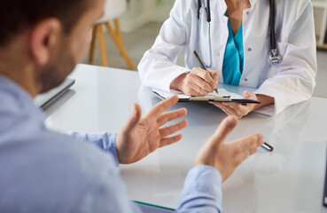 Close-up of patient receiving medical consultation from doctor or nurse during conversation in...
