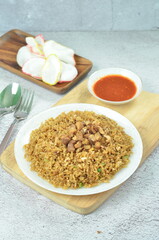 Delicious chicken fried rice with egg, chilli, crackers and green onion, Indonesian dish.