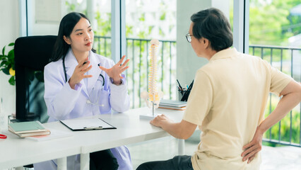 Fototapeta premium An old Asian man consults a doctor about pain in his hips and shoulders to find a way to treat it with life insurance.