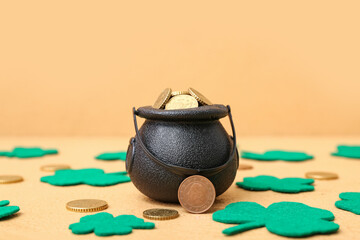 Leprechaun pot with golden coins and clover leaves on beige background. St. Patrick's Day...