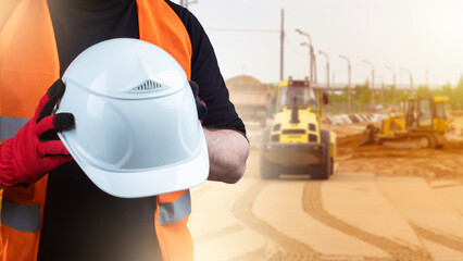 Construction of highways. White helmet in hands of builder. Construction site with engineering...