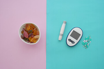 Colorful candies and diabetes tools on pastels