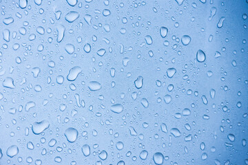 A close-up view of water droplets on a surface, creating a serene blue background with a calming...