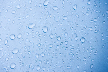 A close-up view of water droplets on a surface, creating a serene blue background with a calming...