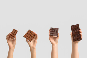 Female hands with different sweet chocolate on white background