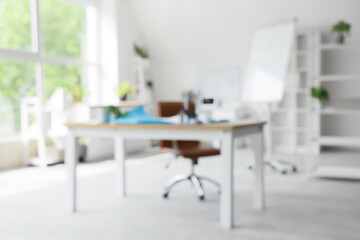 Blurred view of engineer's office with workplace and wind turbine models
