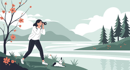 Fototapeta premium A young woman with her dog taking photos of a beautiful landscape with a camera
