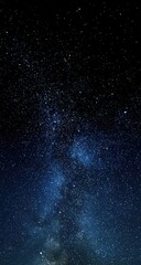 Obraz premium Vertical shot of a dark night sky filled with countless stars, showcasing a prominent Milky Way galaxy with varying densities of starlight