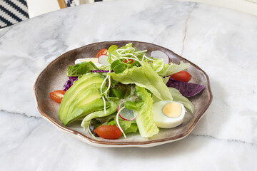 Fresh salad with avocado and tomatoes on a plate