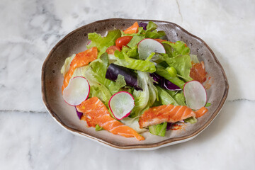 Fresh salad with shrimps and salmon served with vegetables on a plate