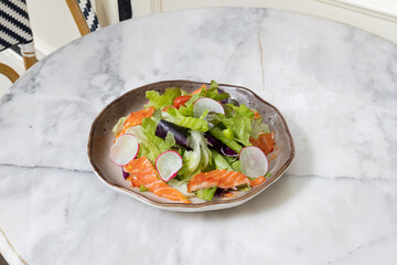 Fresh salad with shrimps and salmon served with vegetables on a plate