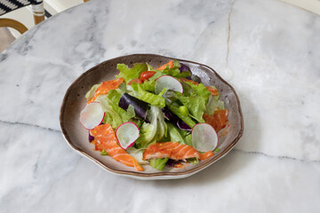 Fresh salad with shrimps and salmon served with vegetables on a plate