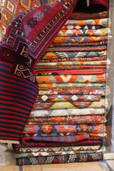 Colorful collection of woven rugs displayed in a market