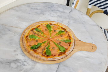 Baked pizza with smoke salmon and melted cheese casserole