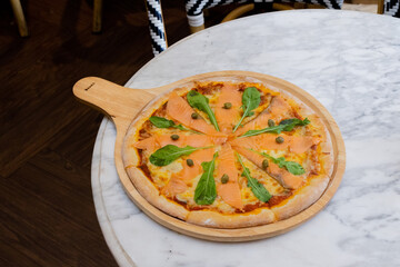 Baked pizza with smoke salmon and melted cheese casserole