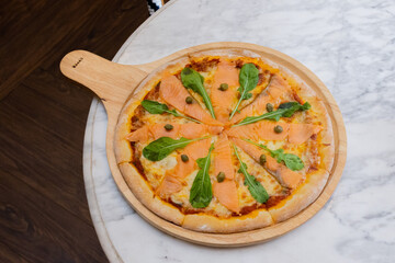 Baked pizza with smoke salmon and melted cheese casserole