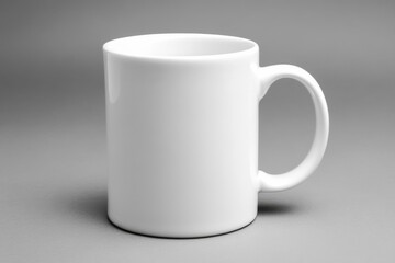 Fototapeta premium A plain white coffee mug positioned on a smooth gray surface, showcasing minimalist design