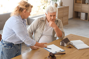 Mature couple signing divorce agreement at lawyer's office
