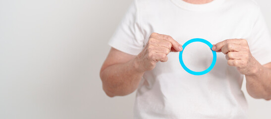 Elderly woman with Blue Circle for World Diabetes Day, Blue November Health month, Diabetes awareness, Blood sugar check, Insulin, Glucose screening, Healthy lifestyle, Chronic disease checkup