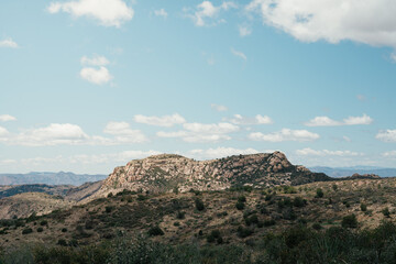 Rocky Hill in Desert Landscape under Cloudy Sky