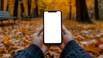 A blank white screen phone is placed in front of autumn leaves.
