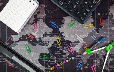 Flat lay with stationery objects on world map background. Back to school concept