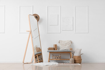 Interior of light room with soft bench, pillows and mirror