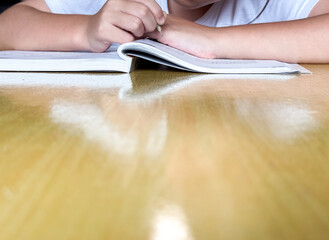 A student engages in independent learning, carefully completing workbook tasks without any assistance.