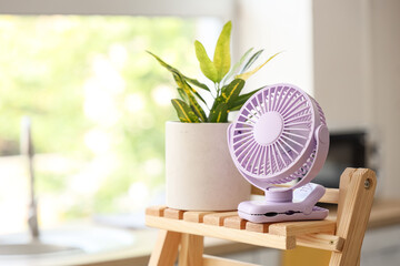Lilac mini fan on shelf in kitchen, closeup