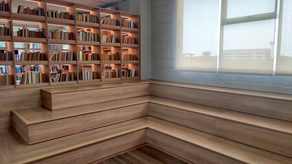 A modern and stylish library corner featuring wooden bookshelves filled with books, illuminated with soft lighting.