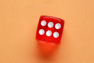 Red game dice on orange background