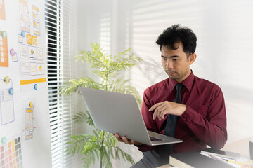 A man is working on a mobile user interface design project. He is focused on the task at hand and appears to be in a creative mood.

