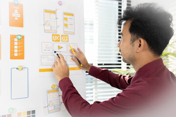 A man is working on a mobile user interface design project. He is focused on the task at hand and appears to be in a creative mood.

